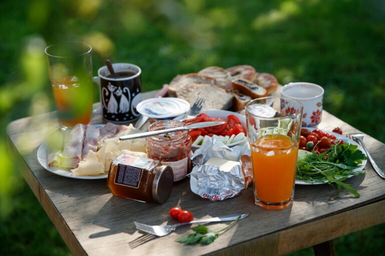 Table de petit-déjeuner en extérieur avec jus de fruits, pain et confitures